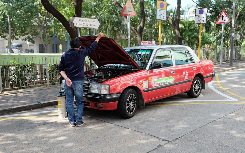 Photo: Michael TracyMechanics doing some sort of fluid replacement on a Toyota Crown taxi.
